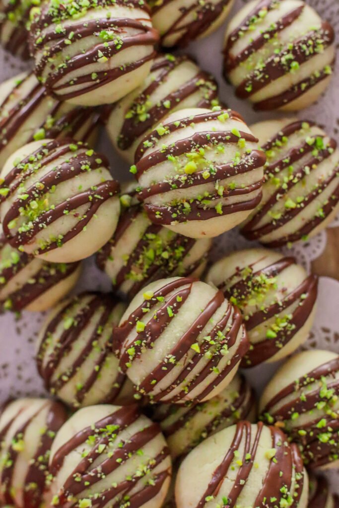 Eggless shortbread balls with chocolate drizzle in a tray