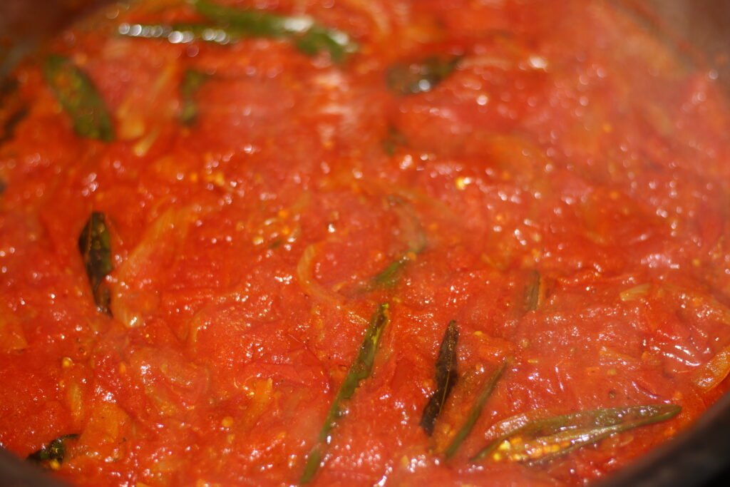 Cook down chopped tomatoes.