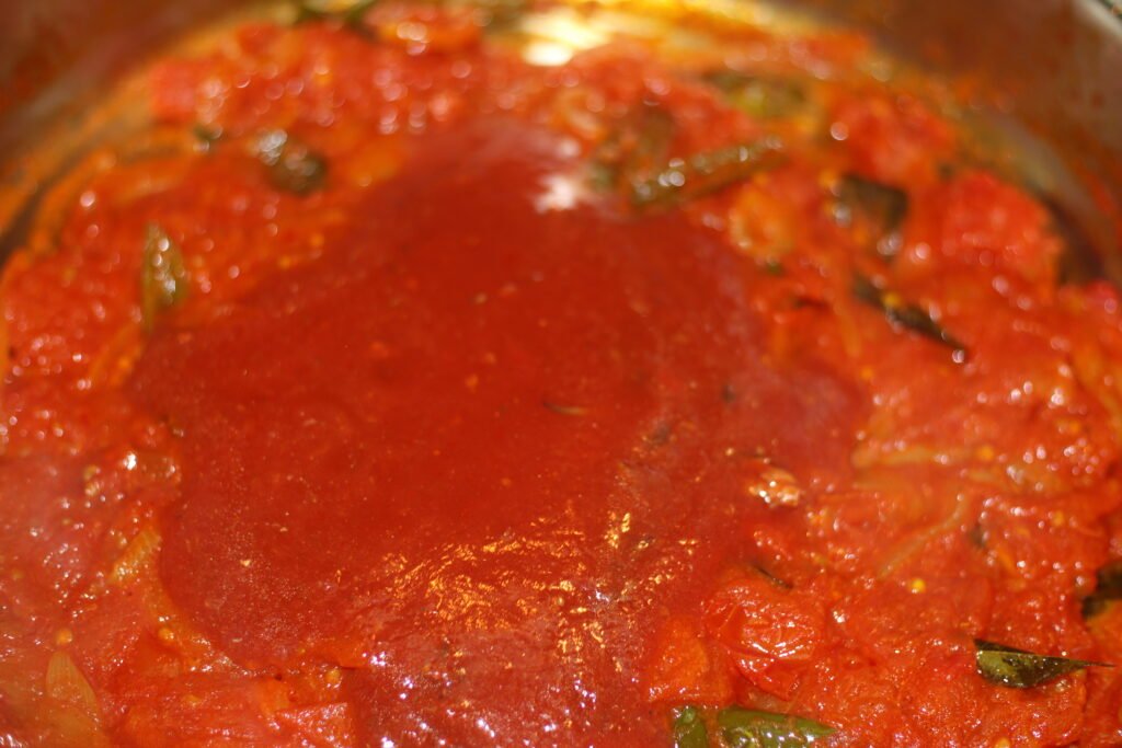 Pour in the tomato sauce from the pilchards tin and stir gently.