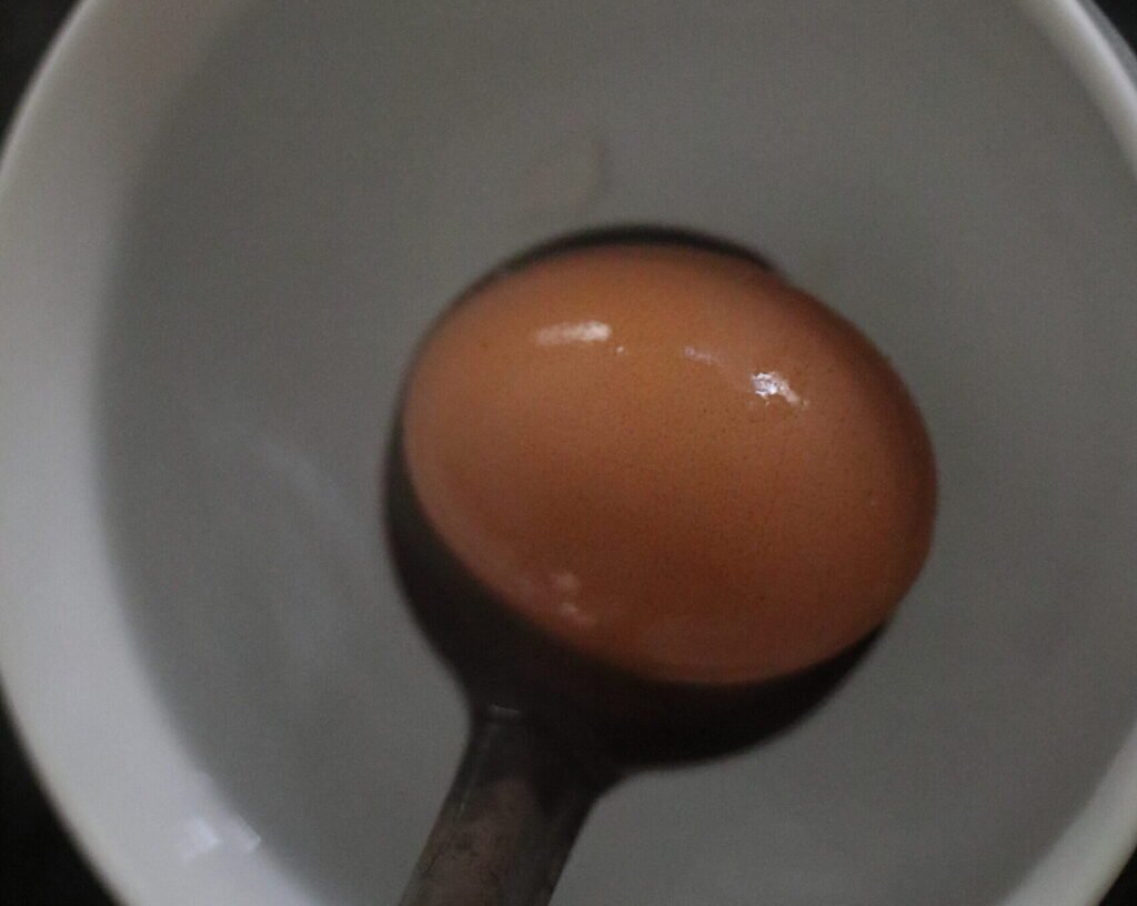 Place boiled egg in cold water to stop the cooking process