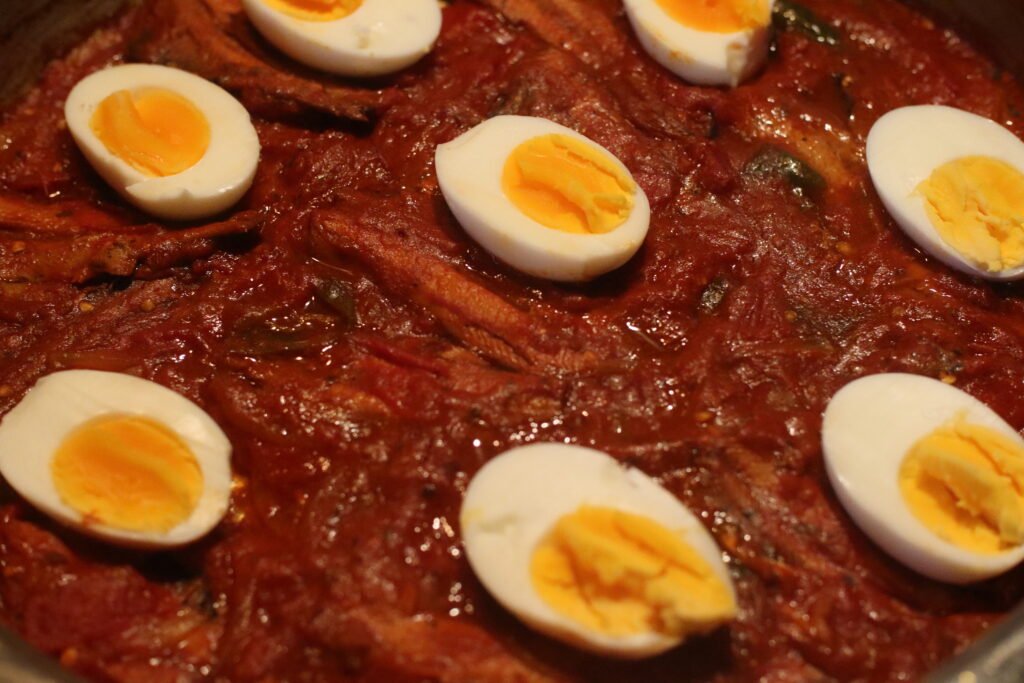 Place sliced boiled eggs over the tinfish chutney