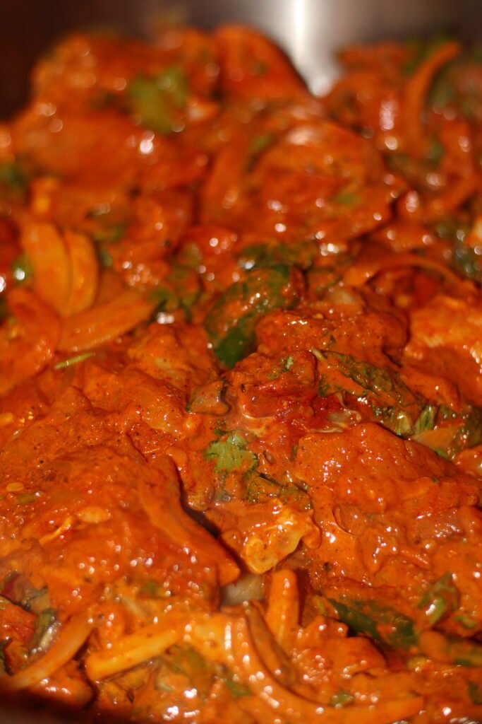 Chicken pieces, halved gravy potatoes and sliced onions marinating in yogurt and spices