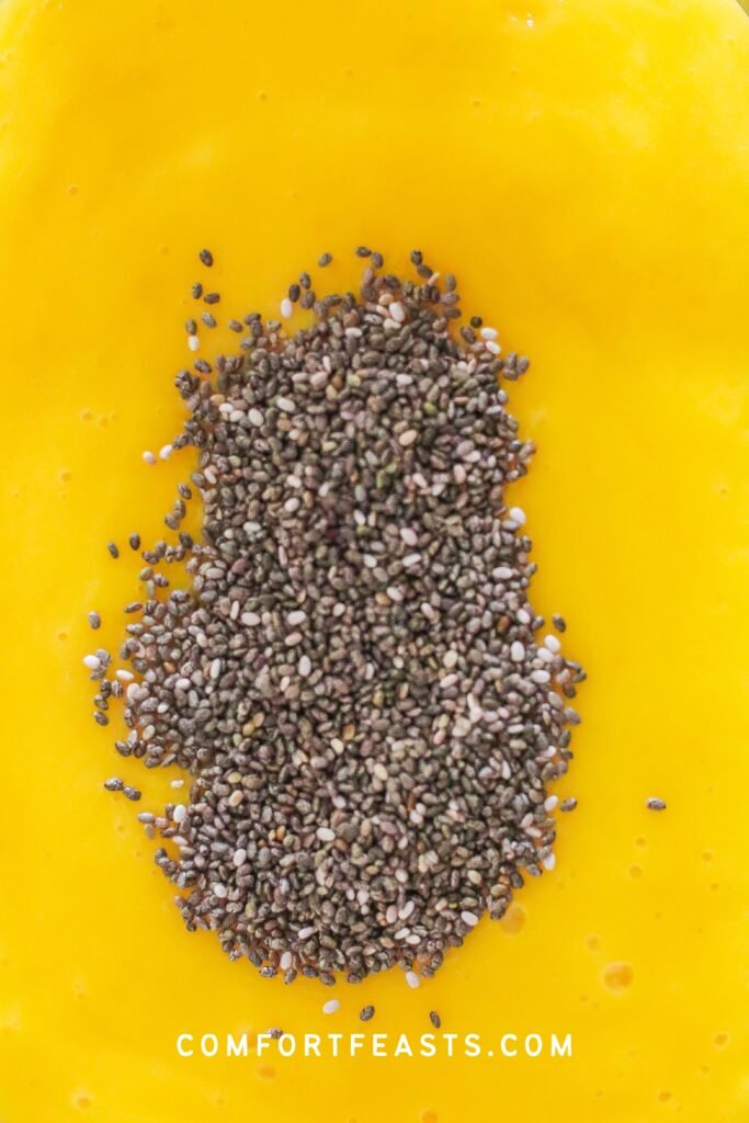 Chia seeds poured into mango mixture
