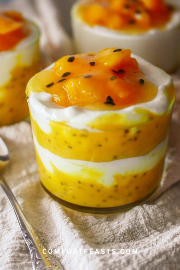 Mango turmeric chia pudding with Greek yogurt in a glass jar and topped with passion fruit pulp