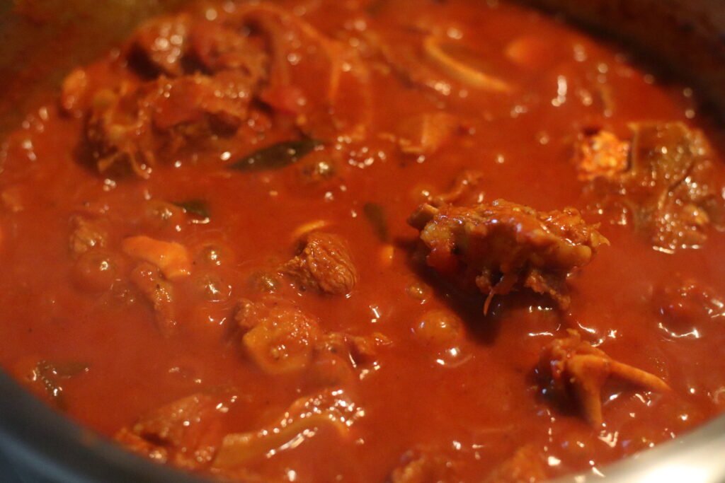 Durban mutton curry slow cooking in pot with lid on