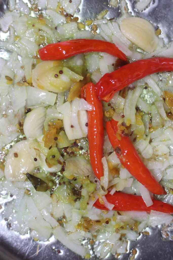 Onions, chillies, and spices cooking in a pot