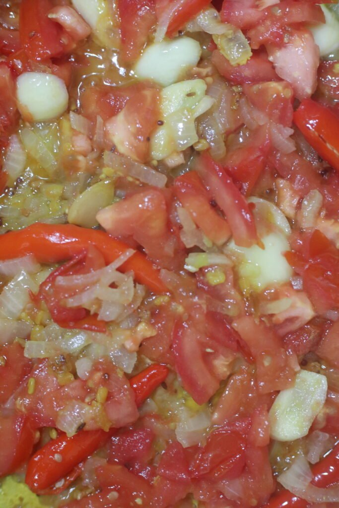 Tomatoes cooking down into a spicy onion mixture