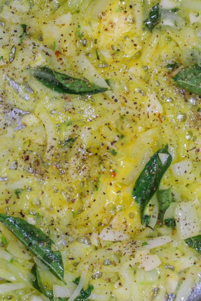 curry leaves, garlic and spices added to butter sauce
