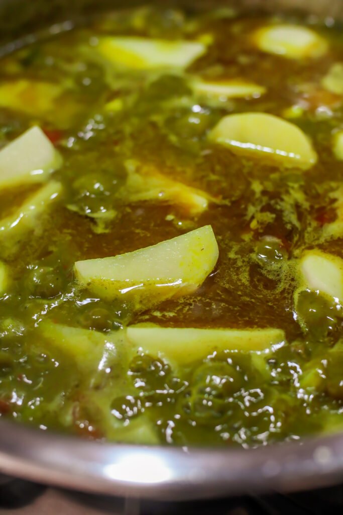 potatoes sitting on top of mutton in pot