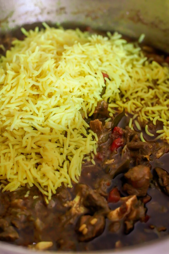 folding basmati rice into green mutton biryani