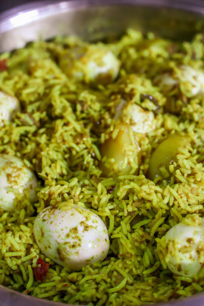 green mutton biryani with boiled eggs combined in pot